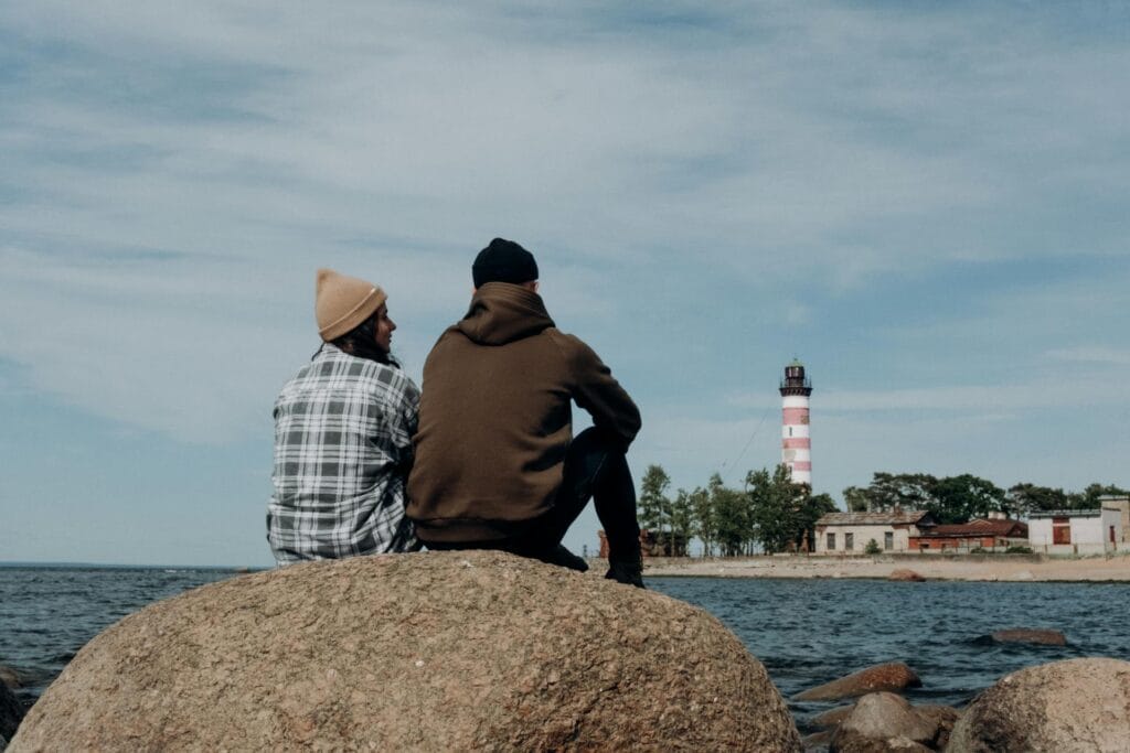 Photo of People Sitting on a Rock